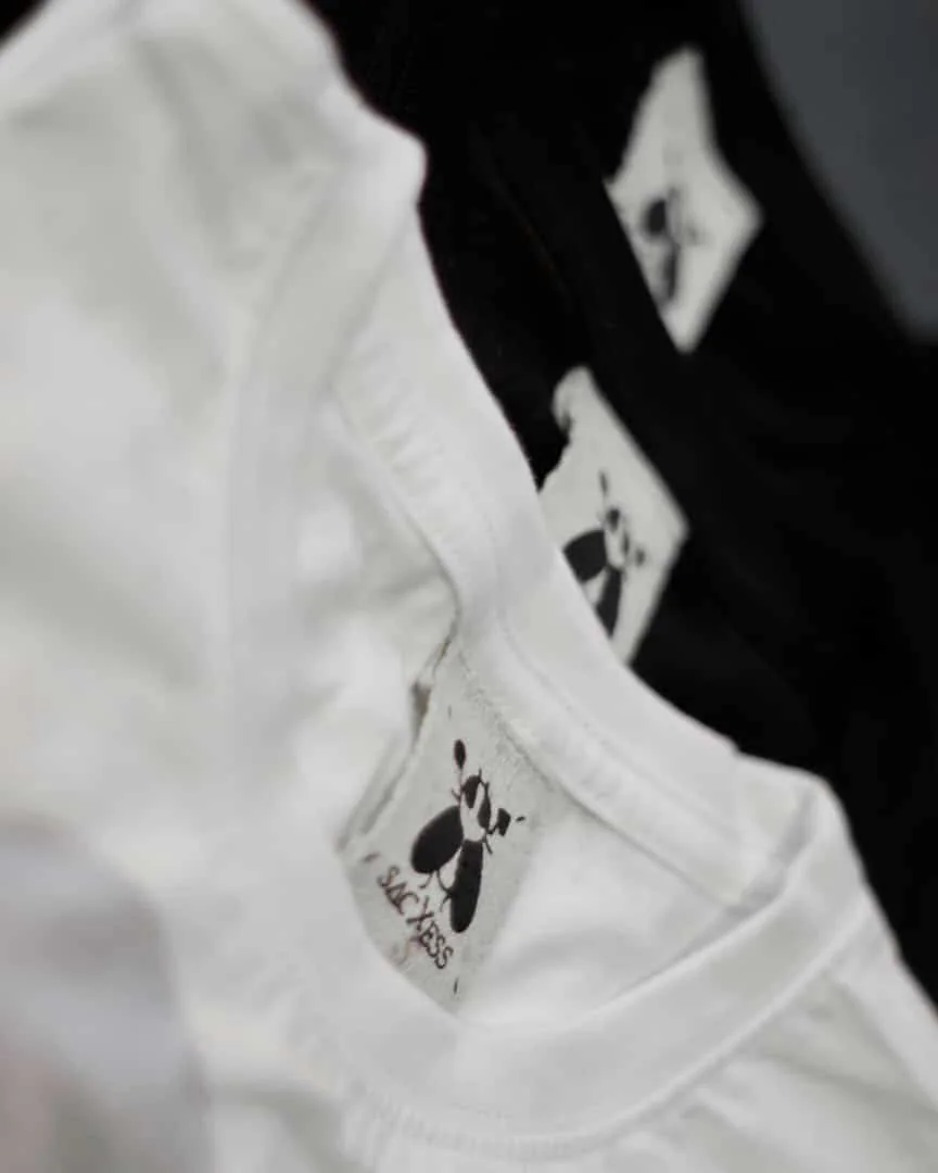 Close detail of the SACXESS woven neck label on a white garment